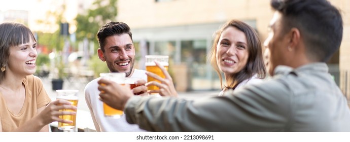 Horizontal banner or header with multiracial friends drinking beer at brewery pub - Genuine friendship life style concept with guys and girls enjoying happy hour food together at open air bar dehor - Shutterstock ID 2213098691