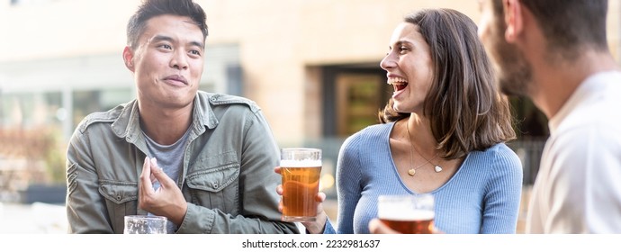 Horizontal banner or header with multiracial friends drinking beer at brewery pub - Genuine friendship life style concept with guys and girls enjoying happy hour food together at open air bar dehor - Shutterstock ID 2232981637