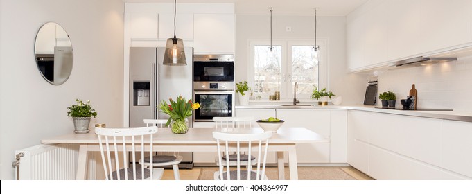 Horizontal Banner Of A Kitchen Interior With Table And White Cupboards