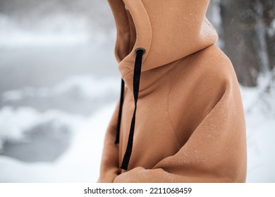 horizontal banner with a model in winter on the street in oversized sand color hoodie.side view at a model.fashion and wear concept.warm oversized wear at girl.space for text and logo.mock up - Shutterstock ID 2211068459