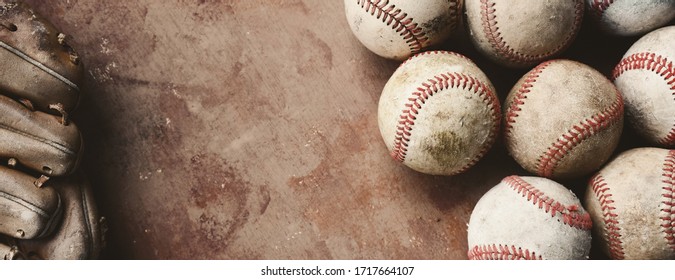 Horizontal banner with old texture of used dirty game balls on brown worn background with copy space by baseball glove.