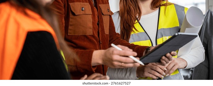 Horizontal banner or template with engineer supervisor at construction site with his female work team setting guidelines in building site office - Teamwork concept