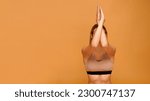 Horizontal banner with a yoga teacher sitting in a cow pose with intertwined eagle hands on orange background