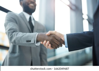Horizontal close up shot of two unrecognizable modern businessmen shaking their hands, copy space - Shutterstock ID 1662049687