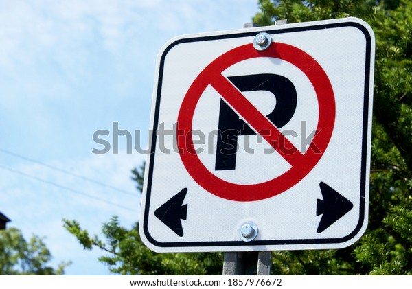 A horizontal closeup image focused\
on a no parking sign used in Canadian traffic\
laws.