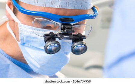 A Horizontal Closeup Of A Mid Adult Surgeon Wearing Surgical Loupe In The Operating Room