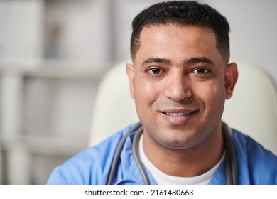 Horizontal Close-up Portrait Shot Of Joyful Young Adult Middle-Eastern Male General Practitioner Looking At Camera Smiling, Copy Space