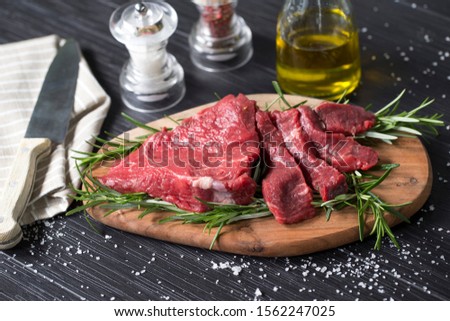 horizontal closeup of a raw italian tagliata, beaf steak., on a wooden chopboard with rosemary, salt and olive oil Stock photo © 