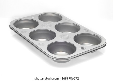 Horizontal Close-up Shot Of An Empty Six-muffin Muffin Pan.  White Background With Shadows.  Copy Space.