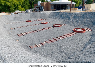 Horizontal close-up shot of four underground fuel storage tanks at new gas station  convenience store construction.