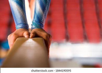 Horizontal close-up shot of a young female gymnast performing on the balance beam. - Powered by Shutterstock