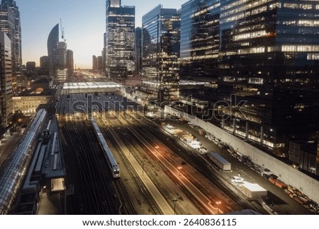 horizontal and elevated point of view of a train terminus downtown a big city with tall buildings on a sunrise