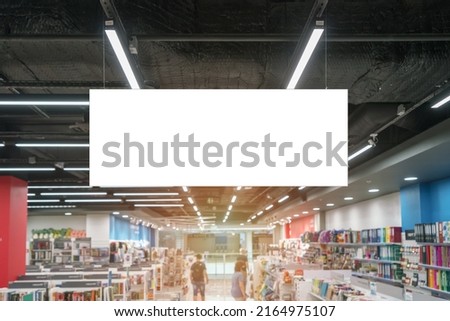 Horizontal empty poster with mockup space hanging on ceiling of bookstore or library indoor