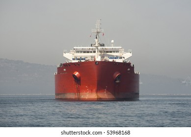 Horizontal front view image of a red Ultra Large Crude Carrier, or "Super Tanker."  These vessels are capable of carrying up to two million barrels of oil across the seas.