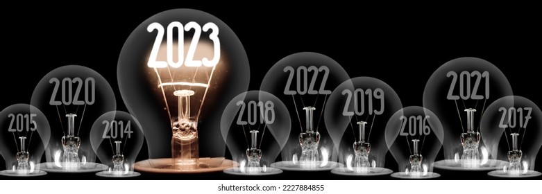 Horizontal group of shining light bulbs with fiber in a shape of New Year 2023 and dark light bulbs with years passed isolated on black background. - Shutterstock ID 2227884855