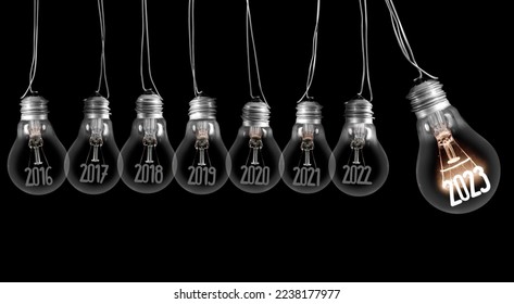 Horizontal group of shining light bulbs with fiber in a shape of New Year 2023 and dark light bulbs with years passed isolated on black background. - Shutterstock ID 2238177977