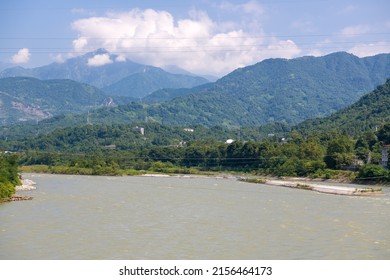 Horizontal image of the big white clouds above the mountains, river rapids, green forest at the Dujiangyan Irrigation System, Dujiangyan, Sichuan, China, copy space for text