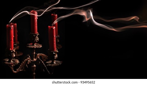 Horizontal image blown candle with line of smoke in massive bronze candlestick