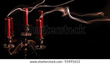 Horizontal image blown candle with line of smoke in massive bronze candlestick