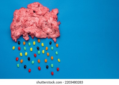 Horizontal Image Of Cloud Of Homemade Pink Candy Floss Raining Jelly Beans, On Blue With Copy Space. Tasty Home Made Sweet Foods.