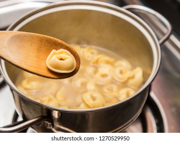 Horizontal Image With Detail Of A Tortellini On A Wooden Ladle While Cooking In A Hot Broth