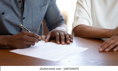 Horizontal Image Man Holding Pen Put Signature On Agreement African Couple Filling Form Bank Application Taking Loan, Affirming Rental Contract, Real Estate Purchasing, Hands And Table Close Up View