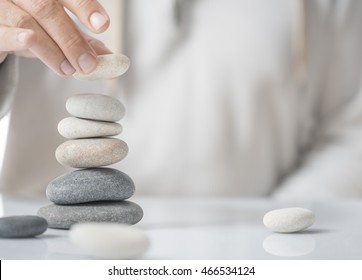 Horizontal Image Of A Man Stacking Pebbles On A Table With Copyspace For Text. Concept Of Personal Development Or Self Realization.