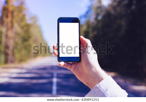 Horizontal image of man\'s\
hand holding smartphone with blank screen with area for your design\
or logo, mockup of modern black cellphone, travel plan.Mock up for\
text message