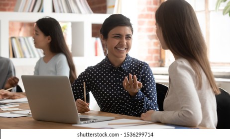 Horizontal image multiracial students seated inside of modern classroom divided into pairs do shared task, indian ethnicity schoolgirl explain thoughts to mate girls thinking together teamwork concept