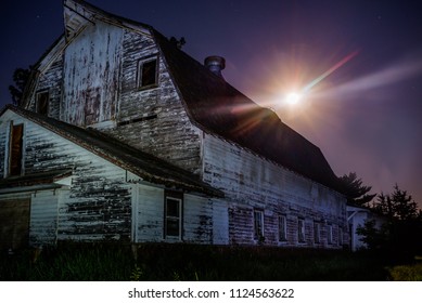 horizontal image old barn with full moon coming up behind.  Night shot using light painting to show abandoned barn and purple night sky with star burst effect on moon.  - Powered by Shutterstock