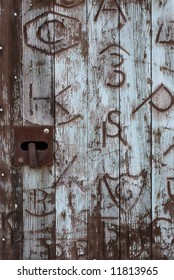 Horizontal Image Of An Old Door Covered In Western Branding Iron Marks