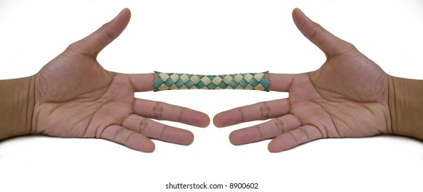 Horizontal image of a pair of hands stuck together in a "Chinese Finge...
