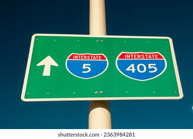 Horizontal image of a roadsign for the Interstsate 5 and Interstate 405 freeways on a lightpole against a blue sky