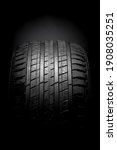 Horizontal isolated in darkness TYRE and tyre pattern, auto equipment having the top surface lighted on black background  