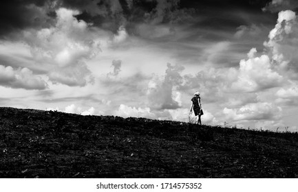 horizontal landscape: girl goes down the road in a field the sky in the clouds, silhouette - Shutterstock ID 1714575352