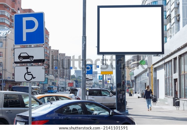 Horizontal large billboard in the\
urban space. Car parking, busy street in the background.\
Mock-up.