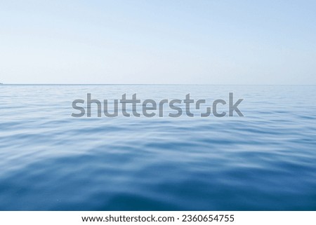 Horizontal line of calm sea surface on the day light. Sea on blue sky background. Seascape in early morning hours under clear sky.