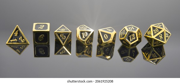 A Horizontal Line of Gold and Black Polyhedral Roll Playing Game Dice with Reflections and Lens Flare. Shallow Depth of Field