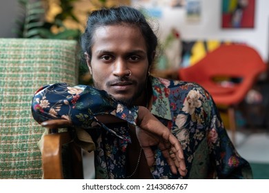 Horizontal medium close-up portrait of handsome androgynous young Indian man wearing shirt with floral pattern looking at camera - Powered by Shutterstock