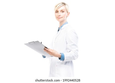 Horizontal medium portrait of beautiful Caucasian doctor wearing white coat holding clipboard with medical card making notes, white background