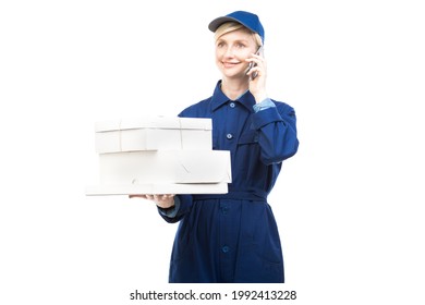 Horizontal Medium Portrait Of Modern Beautiful Caucasian Postal Worker Wearing Blue Uniform Holding Boxes Talking On Phone, White Background