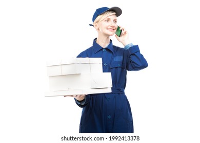 Horizontal Medium Portrait Of Modern Beautiful Caucasian Postal Worker Wearing Blue Uniform Holding Boxes Talking On Phone, White Background