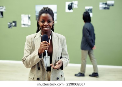 Horizontal Medium Portrait Of Young African American Art Gallery Curator Holding Microphone Speaking About Current Exhibition