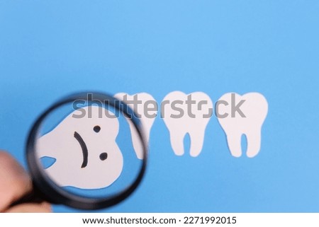 Horizontal, mesial wisdom tooth under a paper magnifier. The concept of medical examination, x-ray