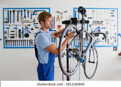 A horizontal mid length shot of young technician working on a bike at cycle service centre. - Powered by Shutterstock