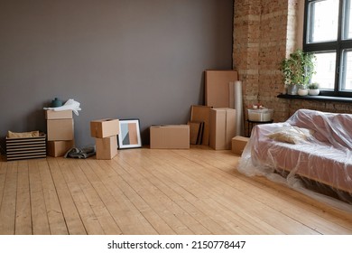 Horizontal No People Shot Of Modern Loft Living Room In Spacious Apartment With Boxes, Sofa And Various Stuff, Moving Concept