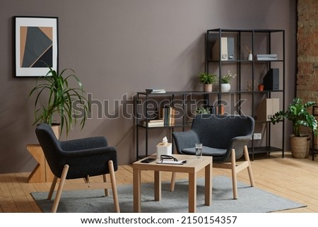 Horizontal no people shot of modern psychologist office interior in gray and brown colors with two chairs and coffee table