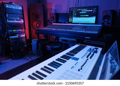 Horizontal No People Shot Of Recording Studio Room Interior With Mixing Console, Digital Piano, Loudspeakers And Other Equipment In Neon Light