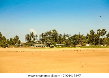 A horizontal panorama of an Indian Village by a beach. 