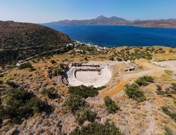 Horizontal Panoramic Aerial Shot Drone Of Ancient Roman Theater In The Tripiti Village At Milos Island, Cyclades, Greece With Sea View